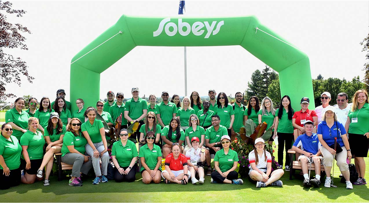 Un groupe d’employés de Sobeys en chandails verts sur un terrain de golf