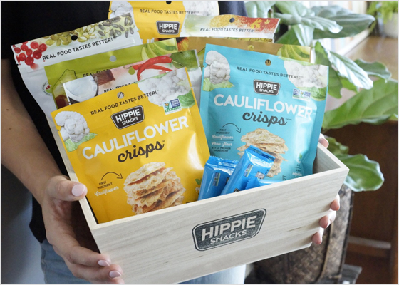 Une personne qui tient une boîte Hippie Snacks.