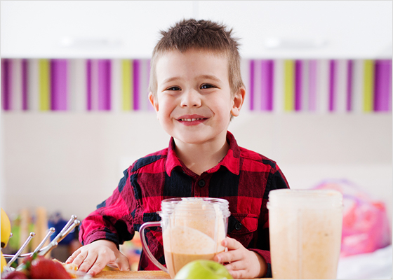 Un jeune garçon boit un smoothie.