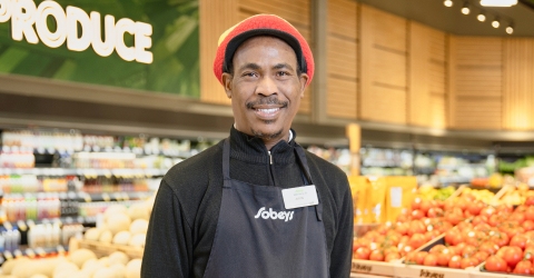 Une image montrant un homme souriant et portant une casquette rouge